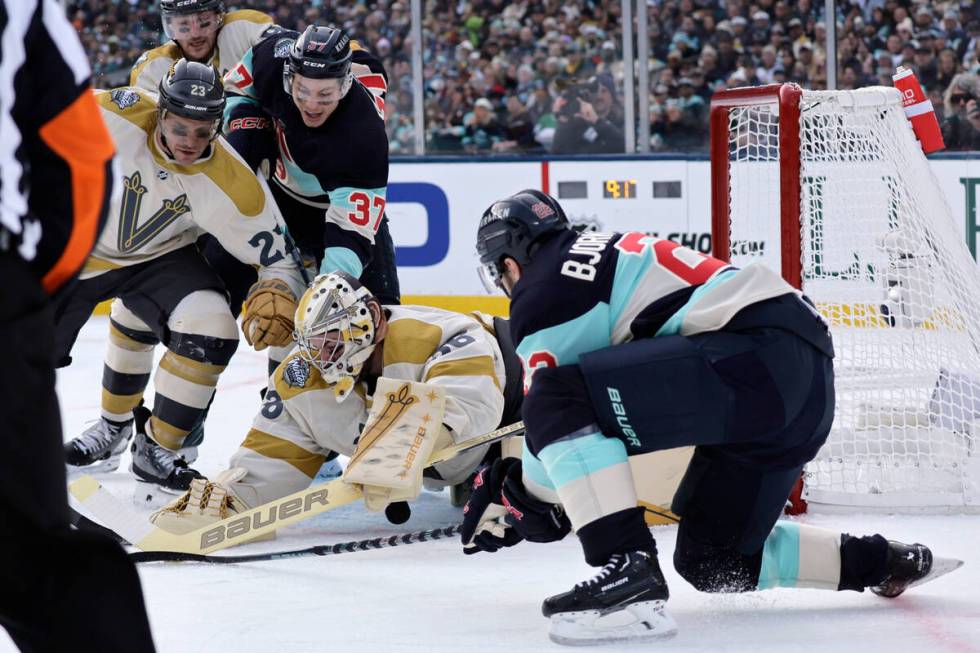 Vegas Golden Knights goaltender Logan Thompson (36) blocks the puck with Seattle Kraken right w ...