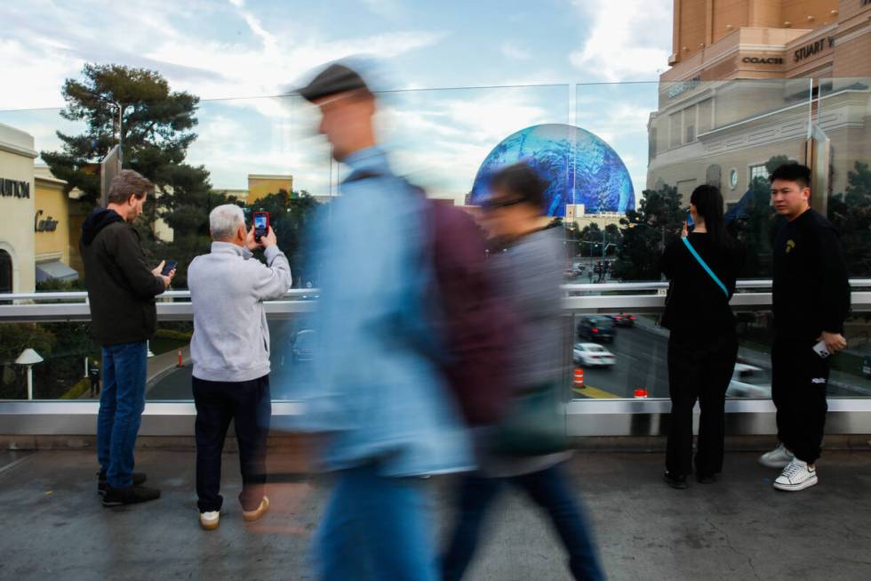 Tourists take pictures along a pedestrian bridge that crosses over Sands Avenue on Tuesday, Jan ...