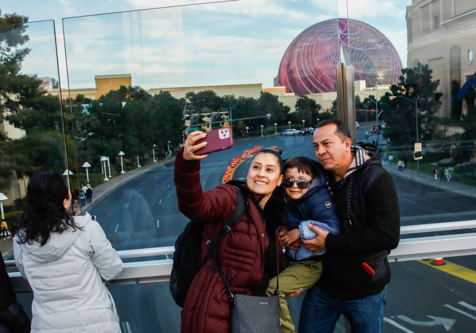 Tourists take pictures along a pedestrian bridge that crosses over Sands Avenue on Tuesday, Jan ...