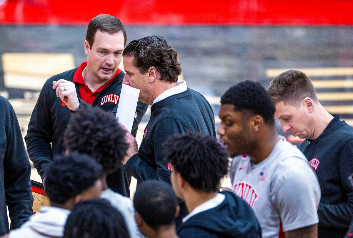 UNLV Rebels head coach Kevin Kruger chats with assistant coach Barret Peery in a timeout agains ...