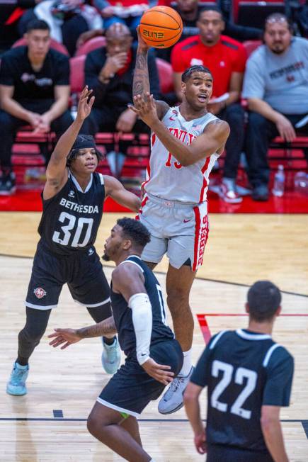 UNLV Rebels guard Luis Rodriguez (15) looks to pass over Bethesda University Flames guard Omari ...