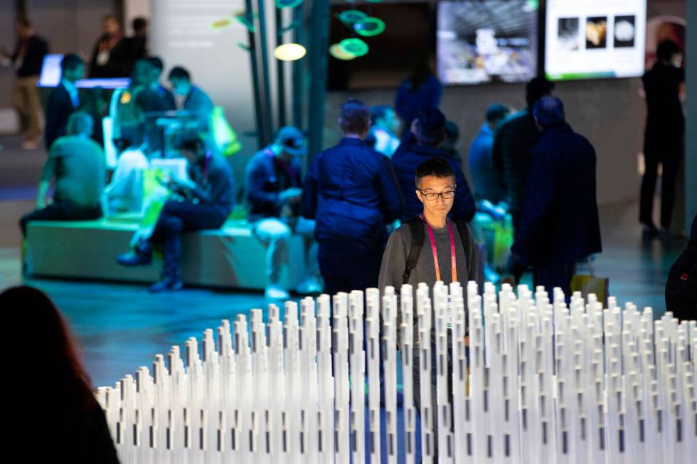 An attendee views a display of rechargeable lithium ion batteries at the Panasonic booth during ...