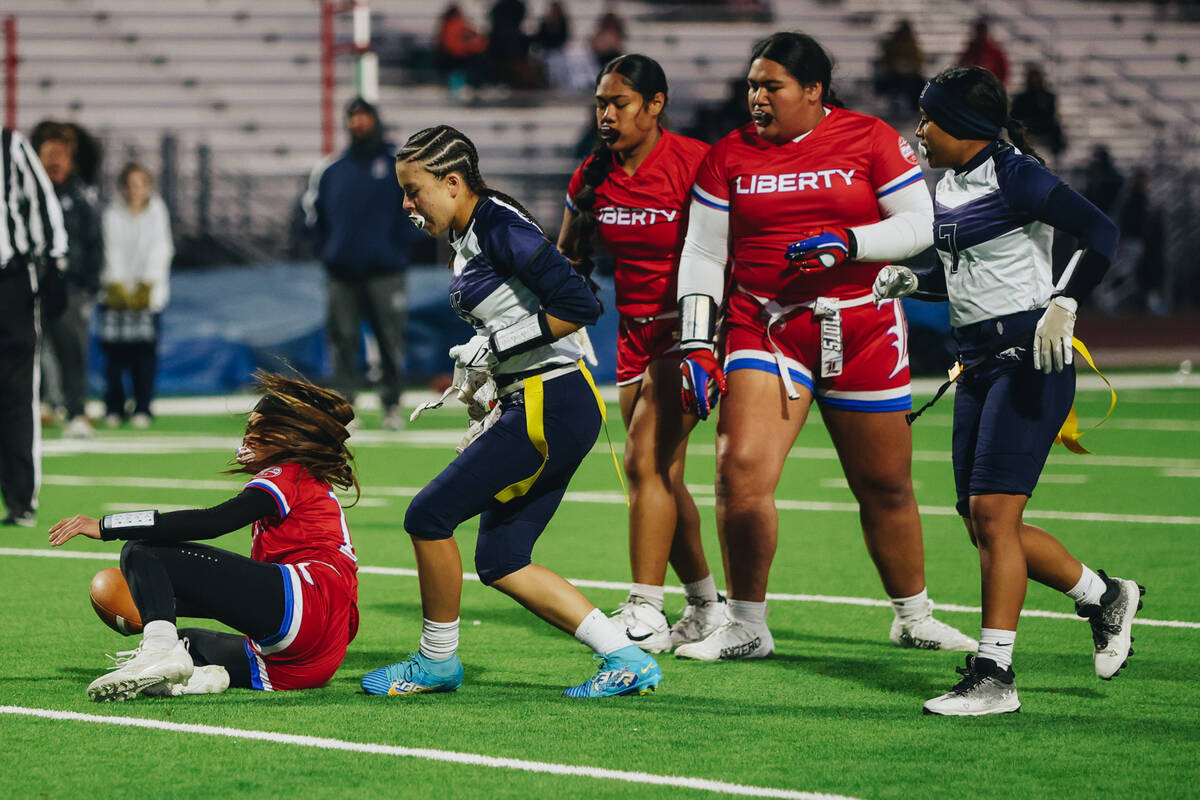 Liberty quarterback Kaylie Phillips (14) falls as her flags get taken during a game against Sha ...