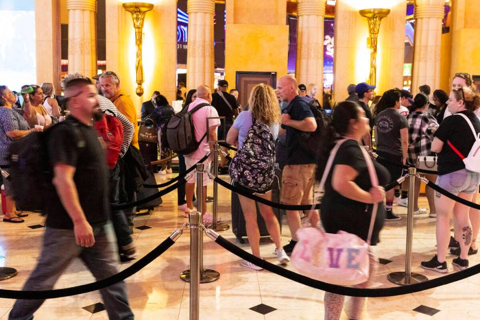 Hotel guests wait in line as they check in at Luxor hotel-casino, on Thursday, Sept. 14, 2023, ...