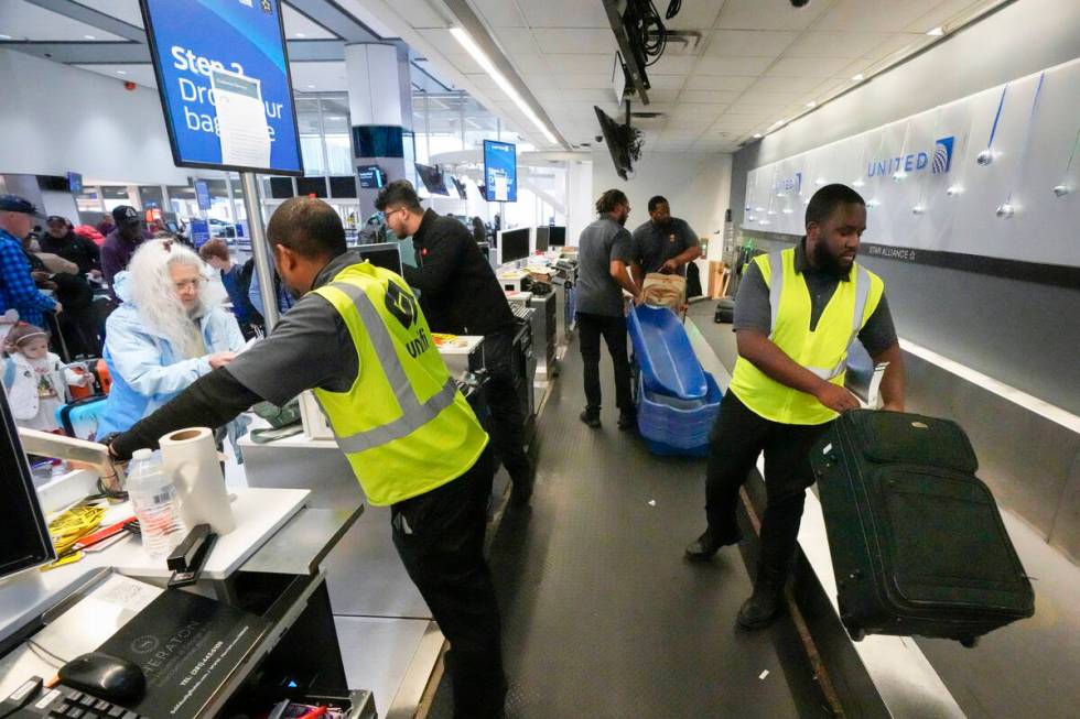 File - Agents check-in passengers and their baggage at George Bush Intercontinental Airport on ...