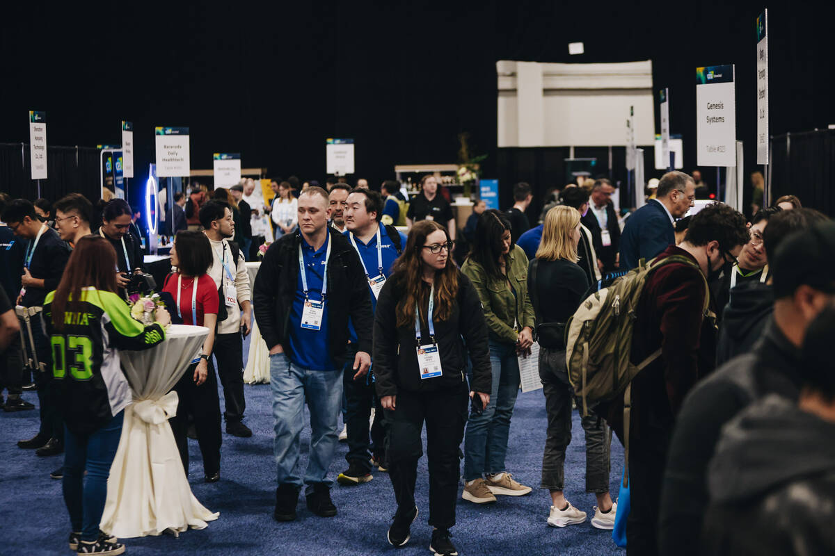 People walk down rows of booths and look at different technology pieces during CES Unveiled at ...
