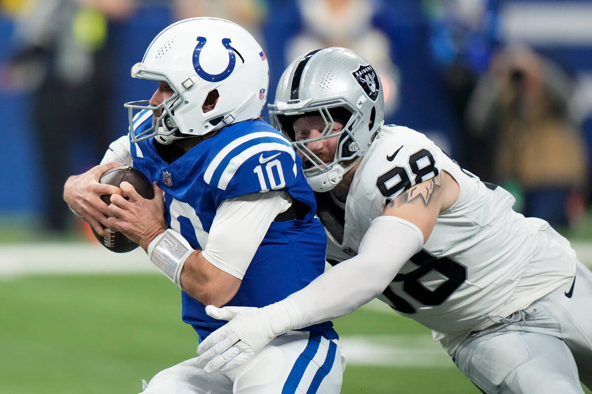 Indianapolis Colts quarterback Gardner Minshew (10) is tackled by Las Vegas Raiders defensive e ...