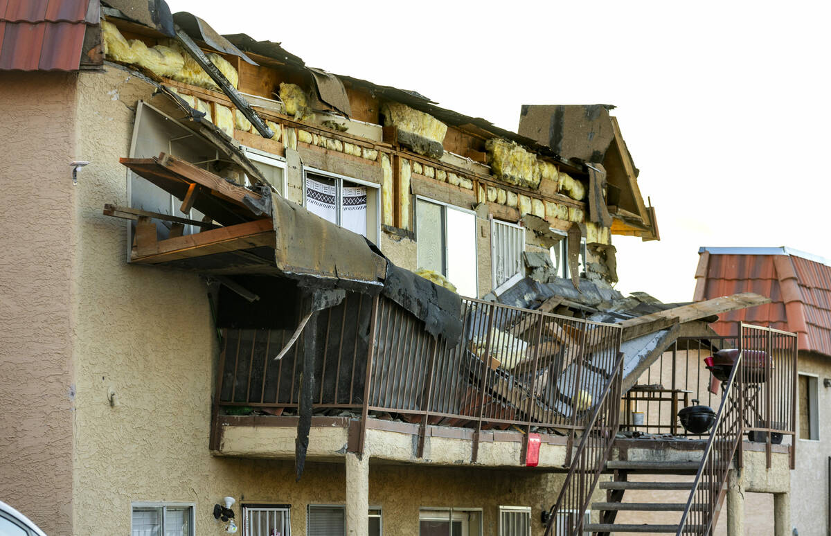 Debris is scattered about the upstairs landing and below from an apartment building roof collap ...