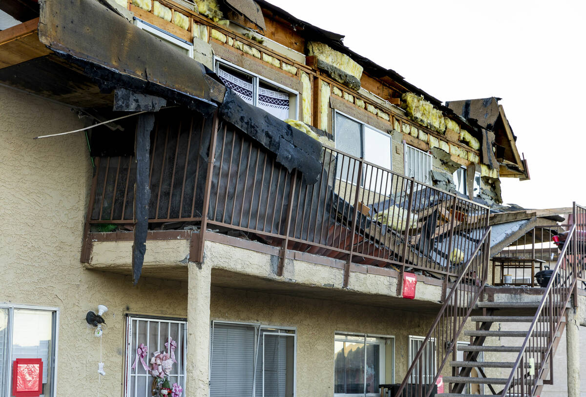 Debris is scattered about the upstairs landing and below from an apartment building roof collap ...