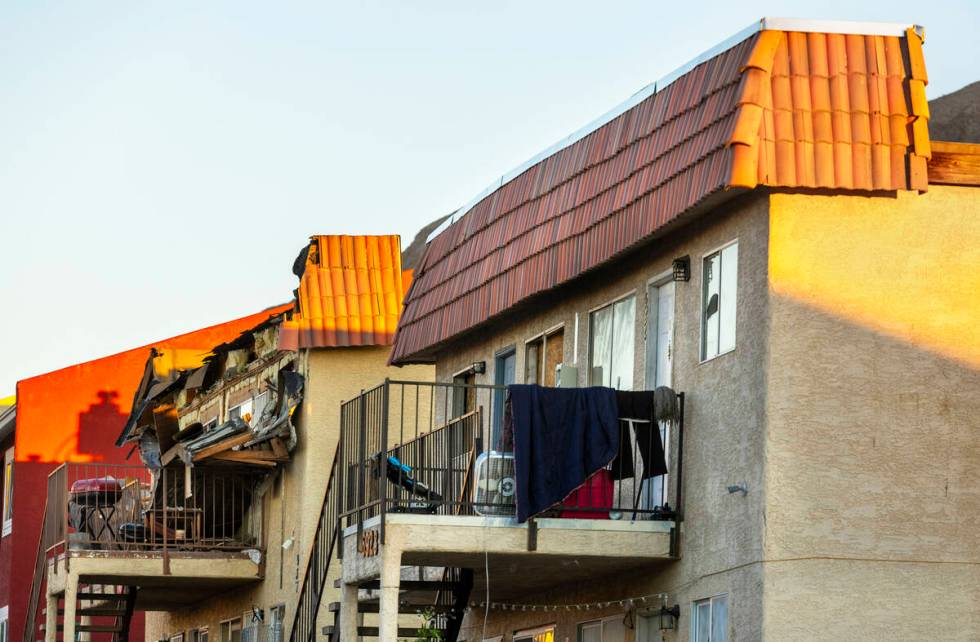 Debris is scattered about the upstairs landing and below from an apartment building roof collap ...