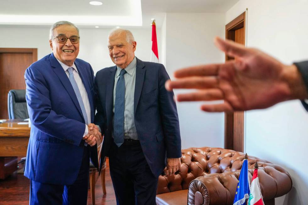 Lebanese Foreign Minister Abdallah Bouhabib, left, shakes hands with European Union foreign pol ...