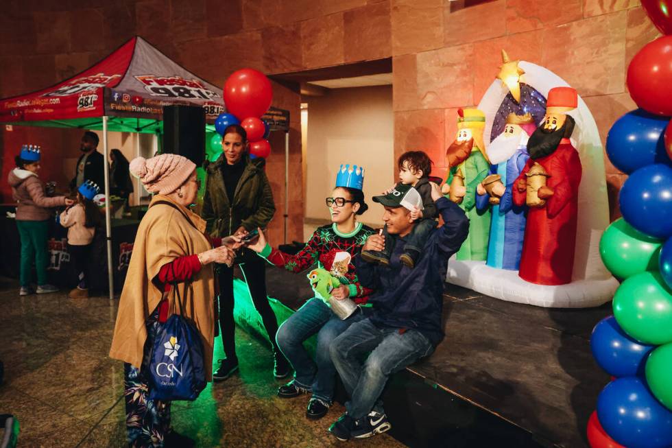 A family takes photos in front of a decoration featuring the Three Wise Men during a Clark Coun ...