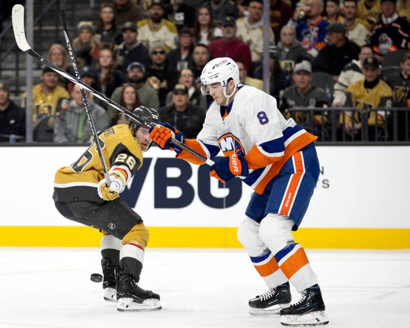 Golden Knights defenseman Tobias Bjornfot (26) loses the puck to Islanders defenseman Noah Dobs ...