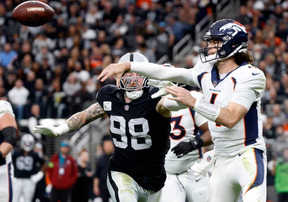Denver Broncos quarterback Jarrett Stidham (4) throws the ball under pressure from Raiders defe ...