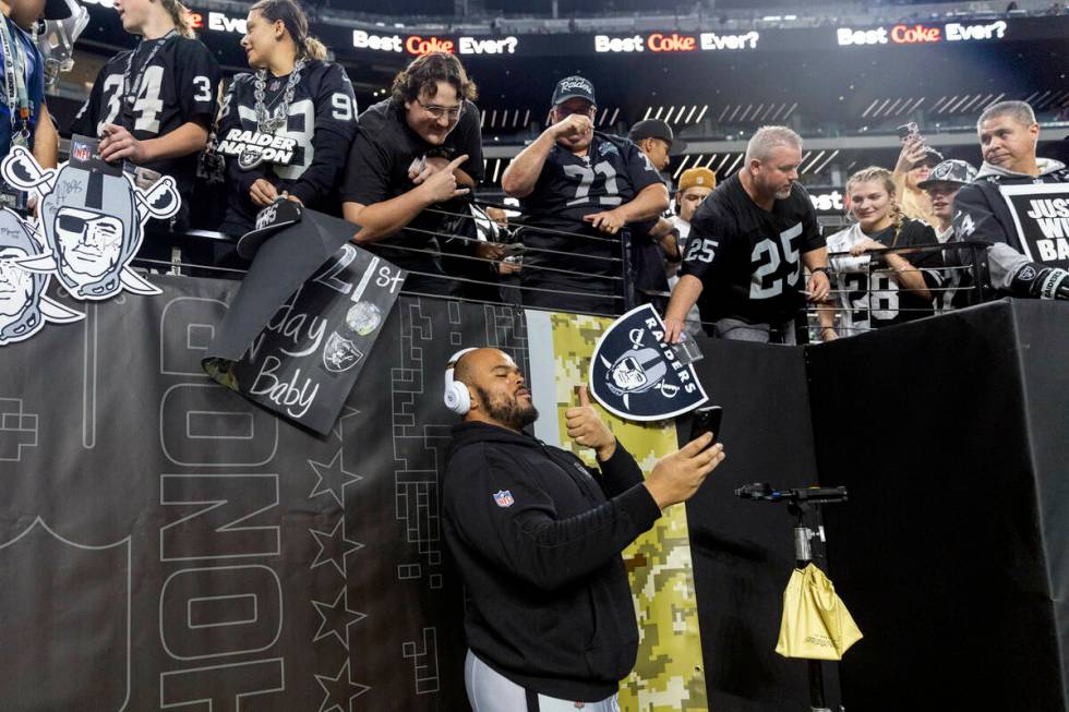 Raiders offensive tackle Jermaine Eluemunor (72) takes a selfie with fans before an NFL game ag ...