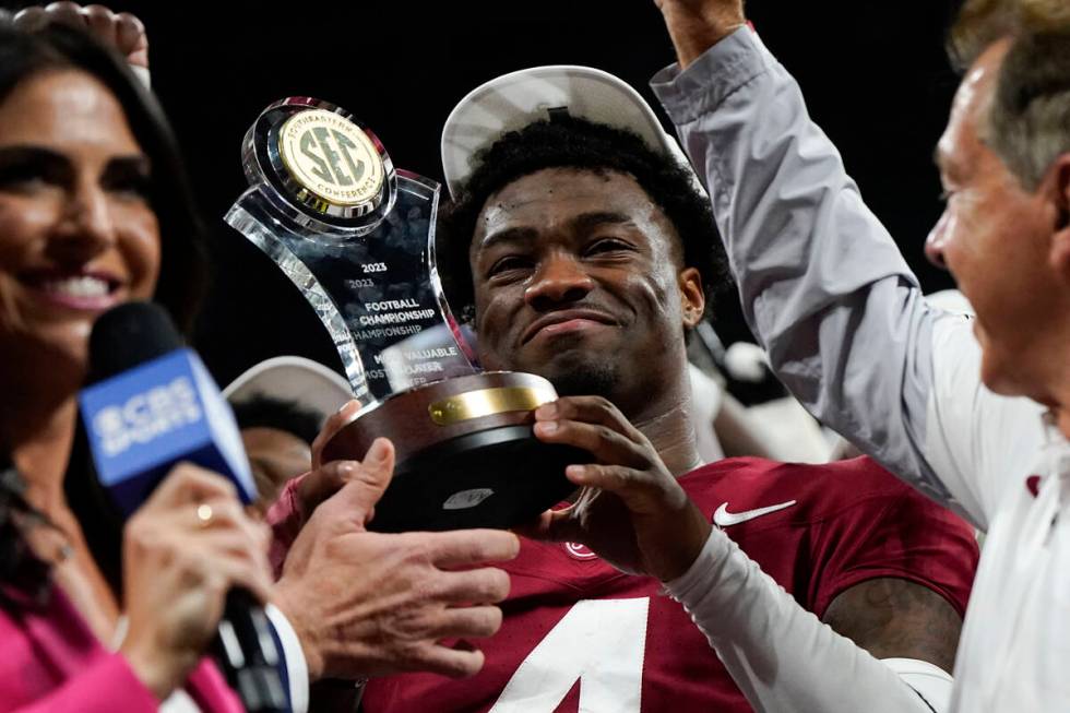 Alabama quarterback Jalen Milroe (4) holds up the most valuable player trophy after the Southea ...