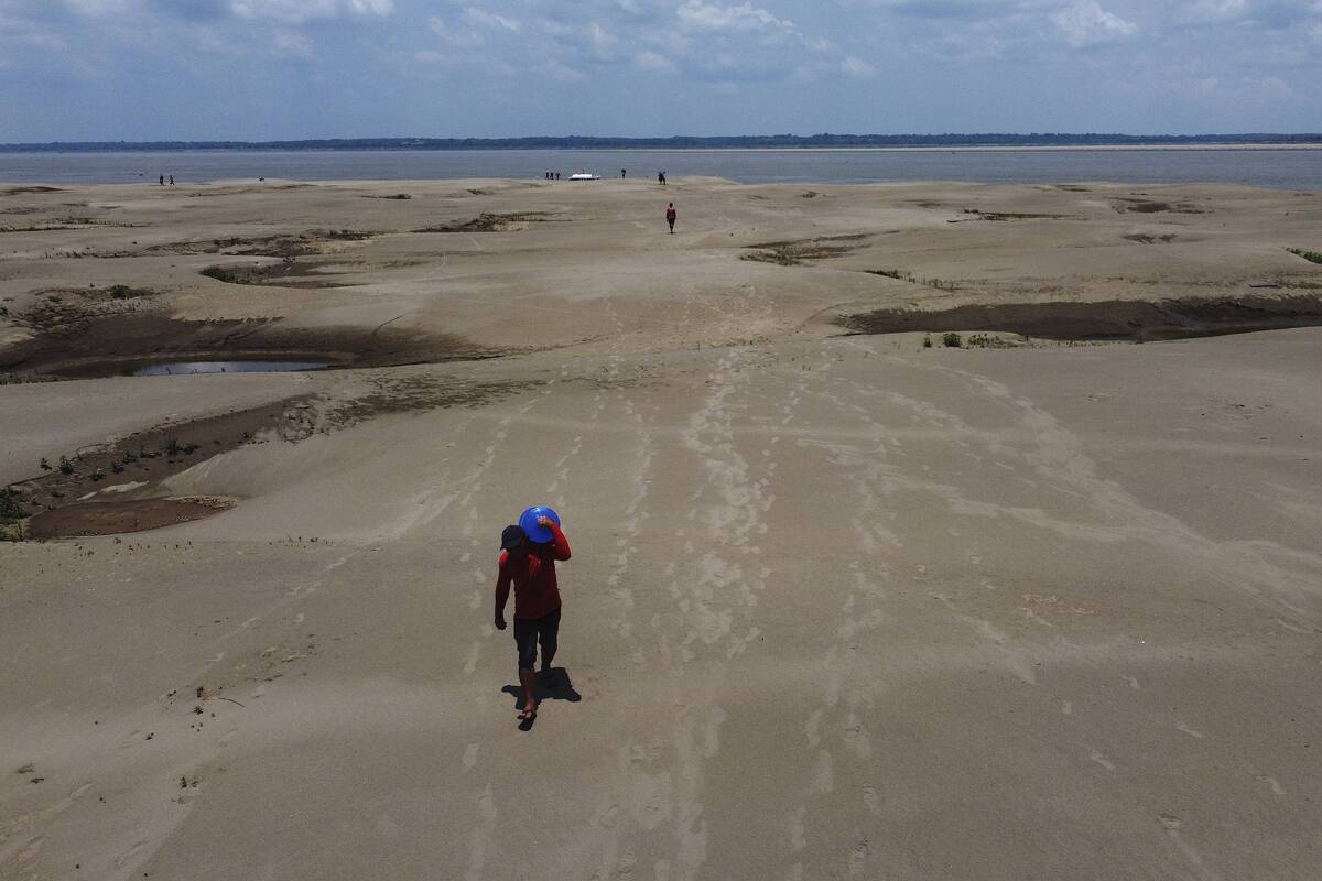 FResidents of a riverside community carry food and containers of drinking water from an aid dis ...