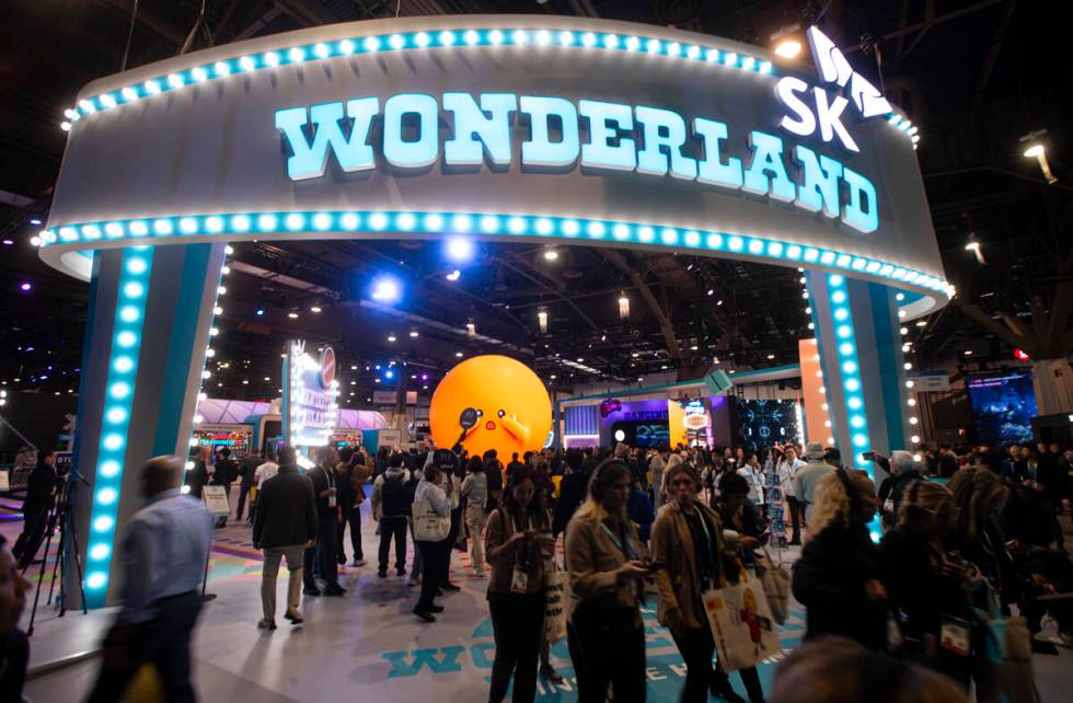 Attendees come and go from the SK Group booth during the first day of CES at the Las Vegas Conv ...