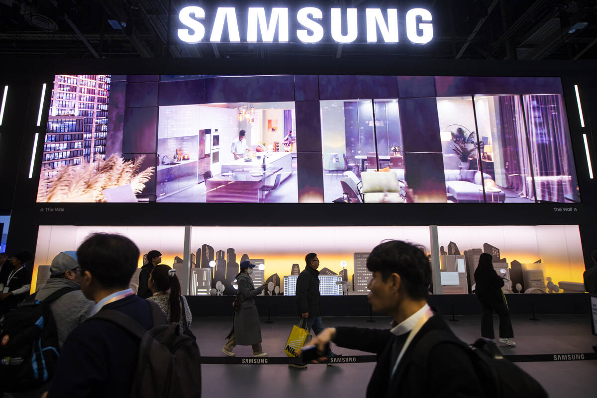 Attendees walk by the Samsung booth during the first day of CES at the Las Vegas Convention Cen ...