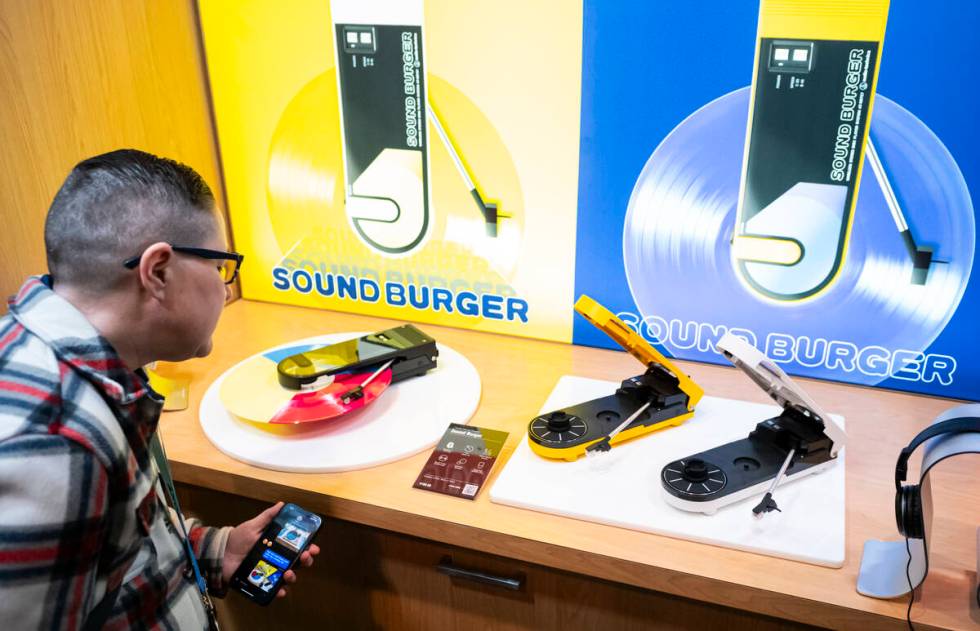 Amy Trombetta, of Texas, looks at the “Sound Burger” portable record players from ...