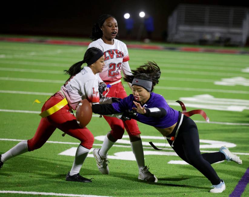 Desert Oasis quarterback Akemi Higa (5) runs past Las Vegas defender Lauren Jirah Dayag (9) in ...