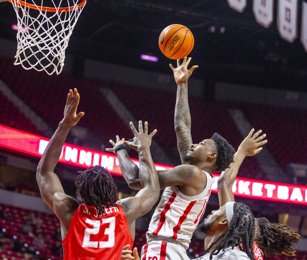 UNLV forward Kalib Boone (10) elevates to shoot over New Mexico Lobos center Nelly Junior Josep ...