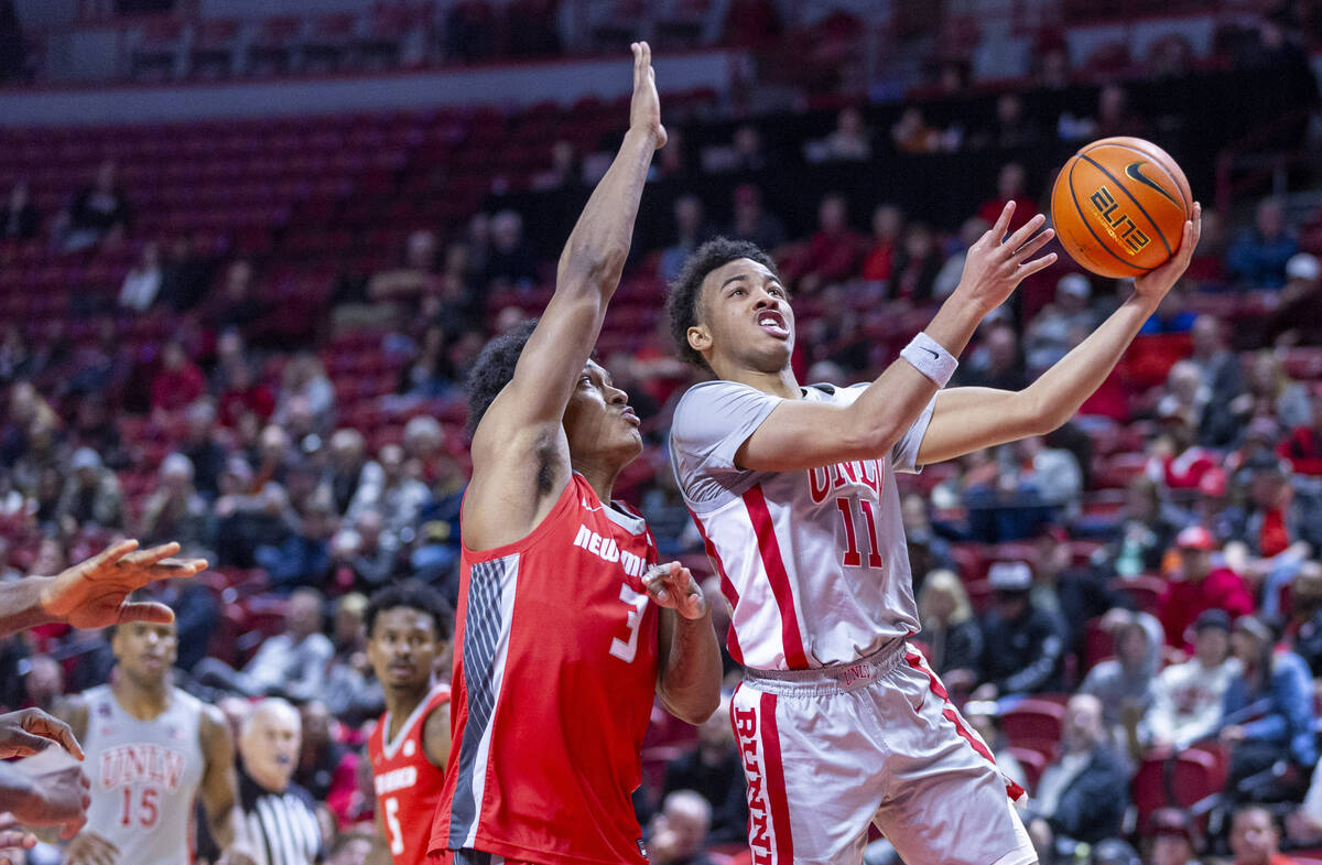 UNLV guard Dedan Thomas Jr. (11) gets inside of New Mexico Lobos guard Tru Washington (3) on a ...