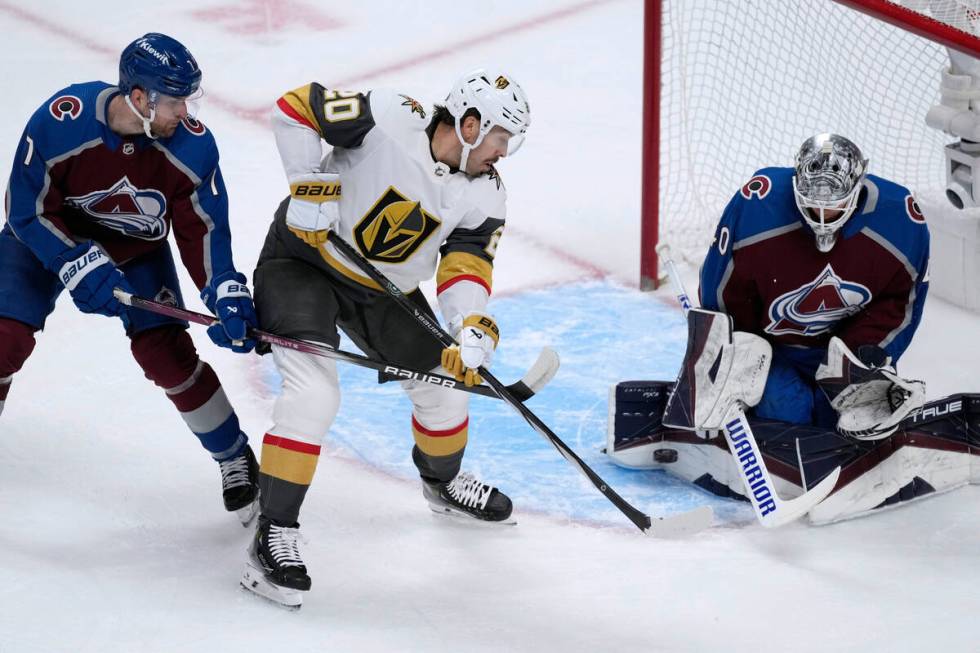 Vegas Golden Knights center Chandler Stephenson, middle, redirects the puck at Colorado Avalanc ...