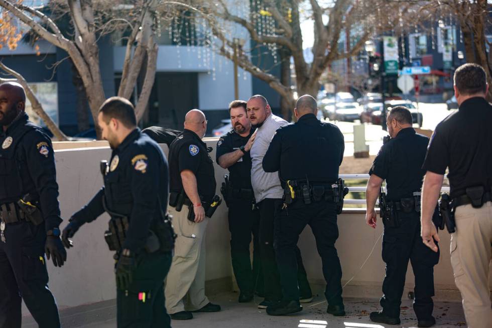 A family member of the victims of a DUI crash is held back by police following his dispute with ...