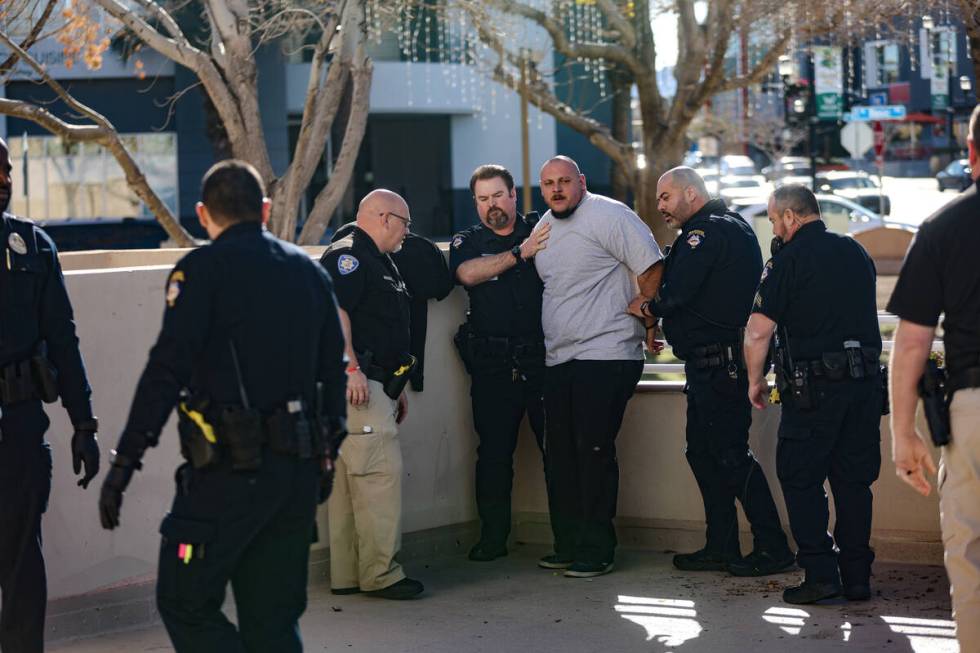 A family member of the victims of a DUI crash is held back by police following his dispute with ...