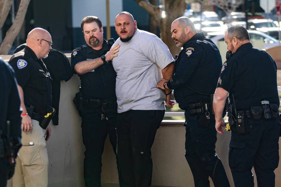 A family member of the victims of a DUI crash is held back by police following his dispute with ...