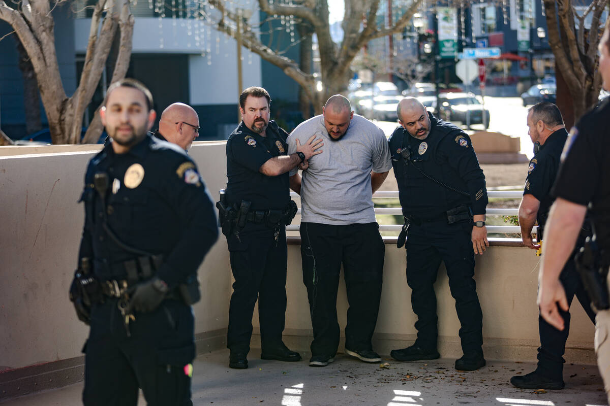 A family member of the victims of a DUI crash is held back by police following his dispute with ...