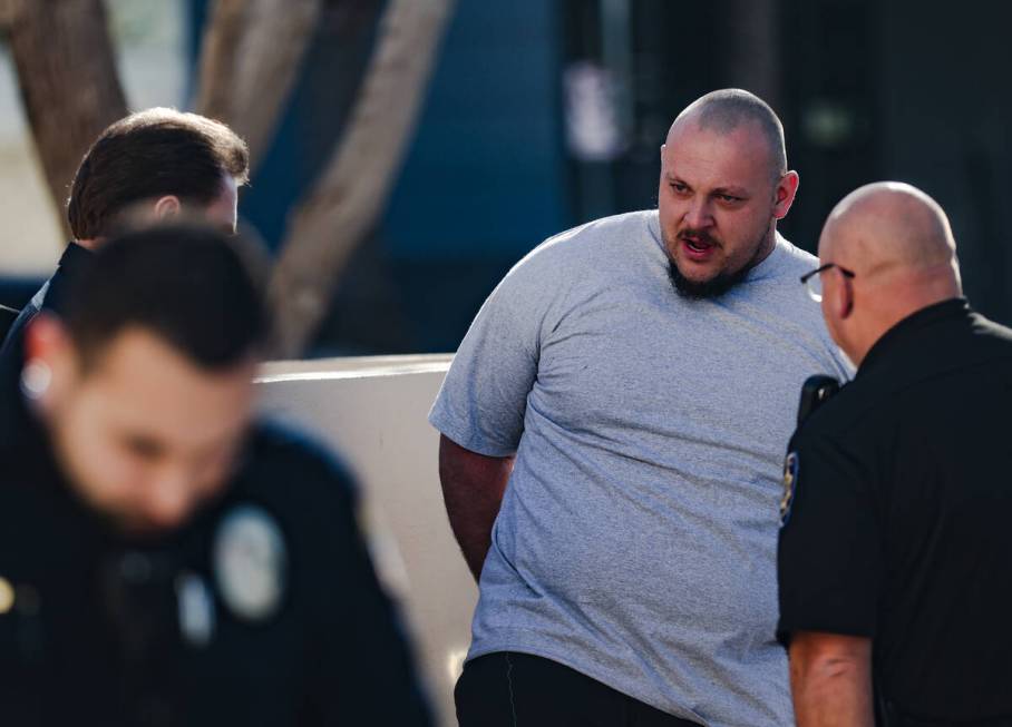 A family member of the victims of a DUI crash is held back by police following his dispute with ...