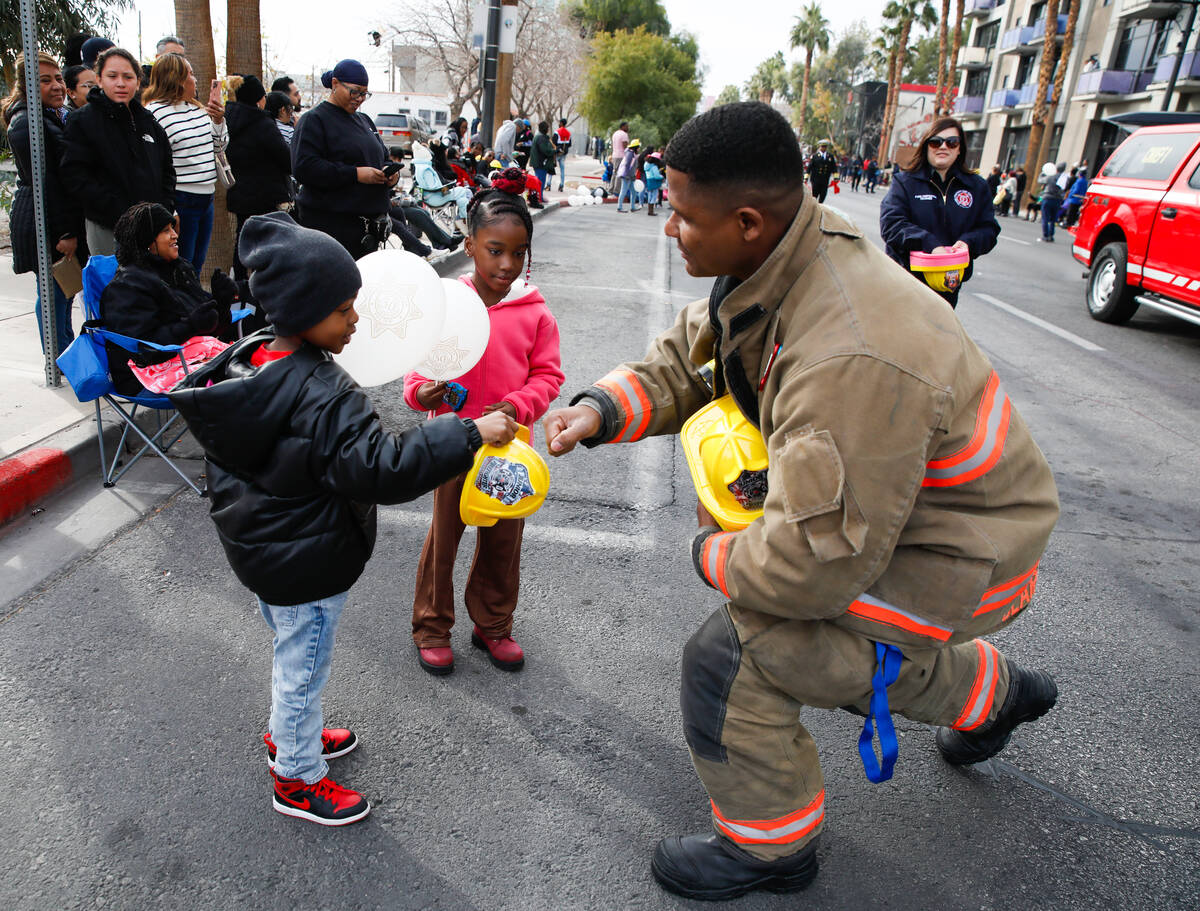 Dishone Gregory with the Clark County Fire Department hands out fire hats to AJ Henry and Maliy ...