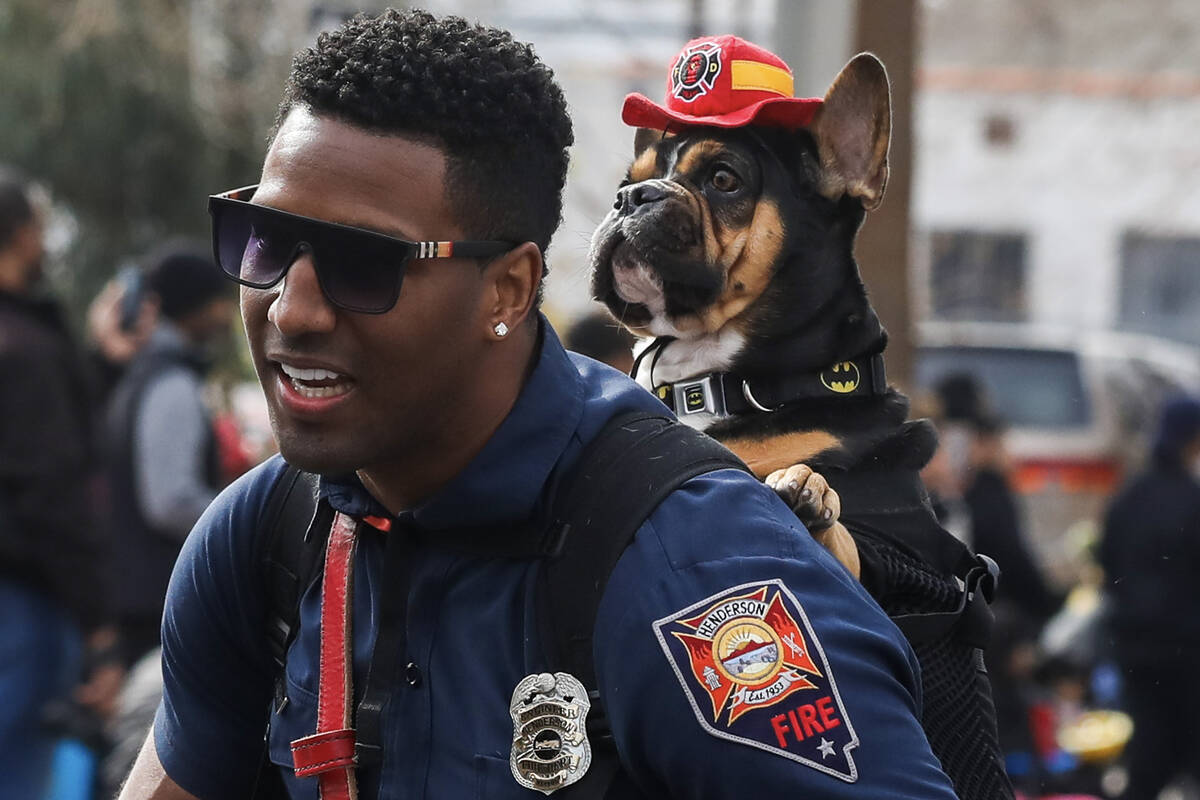 Jason Beauchamp with the Henderson Fire Department marches with his dog during the annual Marti ...