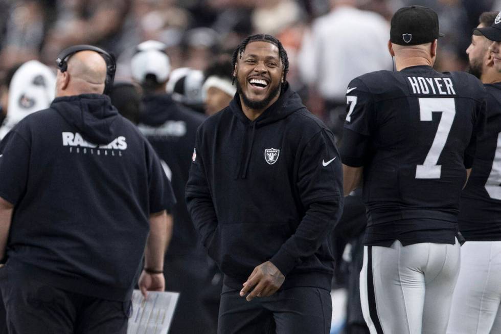 Raiders running back Josh Jacobs laughs on the sideline during the first half of an NFL game ag ...