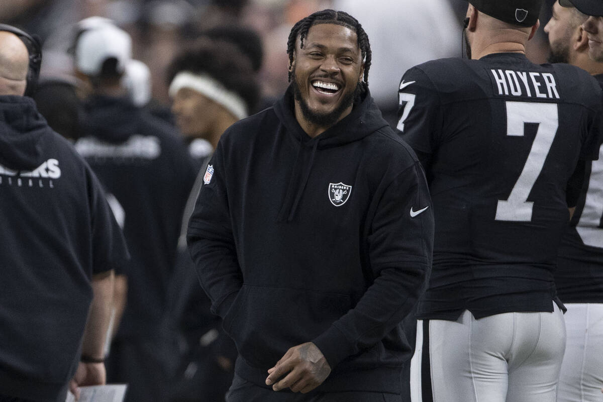Raiders running back Josh Jacobs laughs on the sideline during the first half of an NFL game ag ...