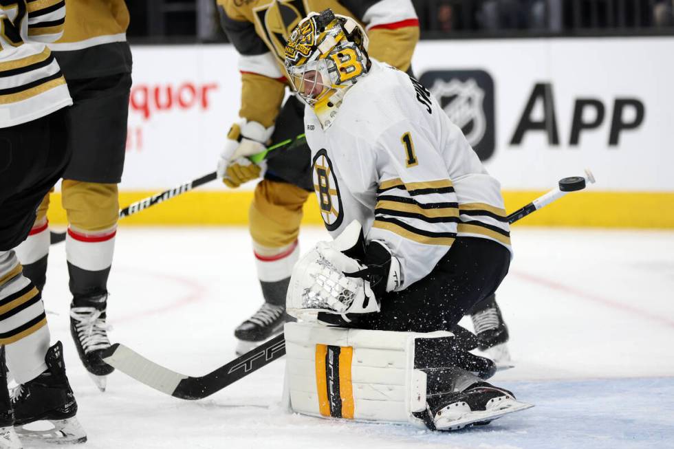 Bruins goaltender Jeremy Swayman (1) deflects the puck during the first period of an NHL hockey ...