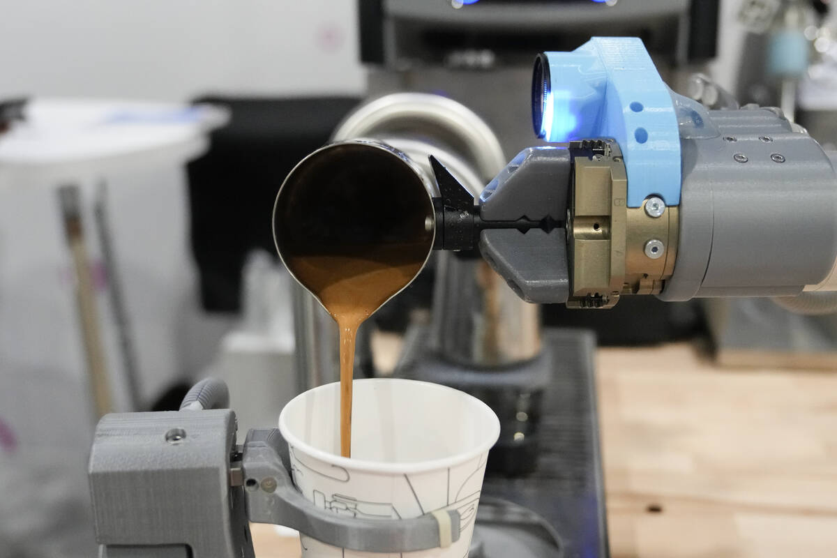 The Artly barista robot serves a drink during the CES tech show Wednesday, Jan. 10, 2024, in La ...