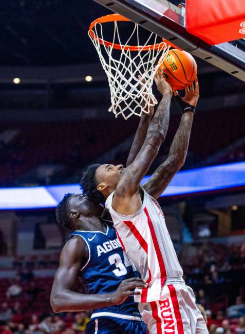 UNLV forward Kalib Boone (10) bodies up to the boards against Utah State Aggies forward Kalifa ...