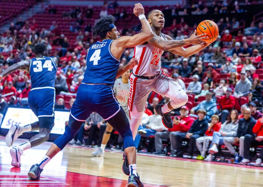 UNLV guard Jackie Johnson III (24) extends past Utah State Aggies guard Ian Martinez (4) for a ...