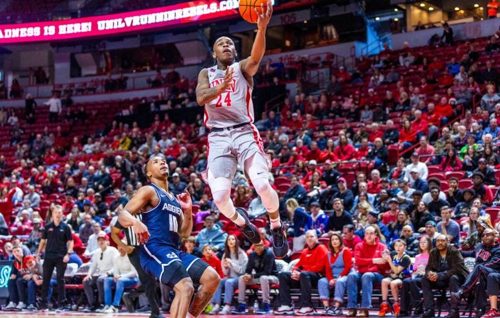 UNLV guard Jackie Johnson III (24) elevates for a basket over Utah State Aggies guard Darius Br ...