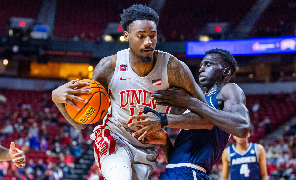 UNLV forward Kalib Boone (10) is held by Utah State Aggies forward Kalifa Sakho (34) during the ...