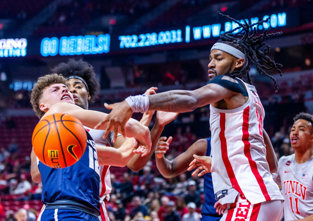 UNLV forward Keylan Boone (20) slaps the ball away from Utah State Aggies guard Mason Falslev ( ...