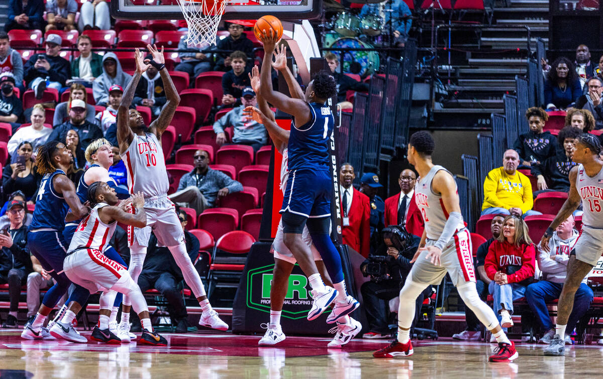 UNLV forward Kalib Boone (10) and teammates attempt to defend the basket from Utah State Aggies ...