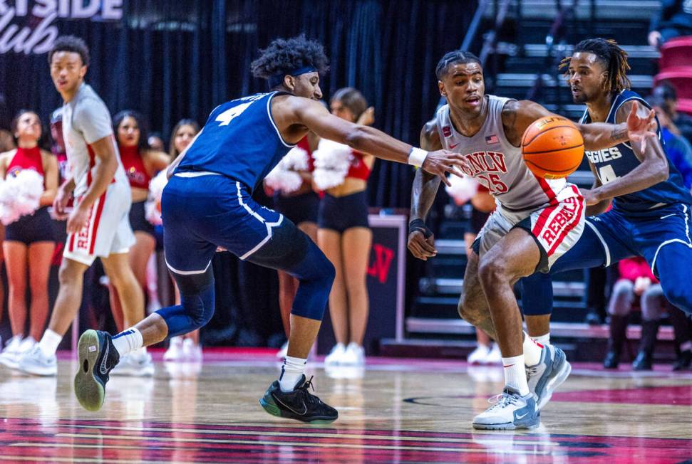 UNLV guard Luis Rodriguez (15) steals the ball from Utah State Aggies guard Ian Martinez (4) du ...