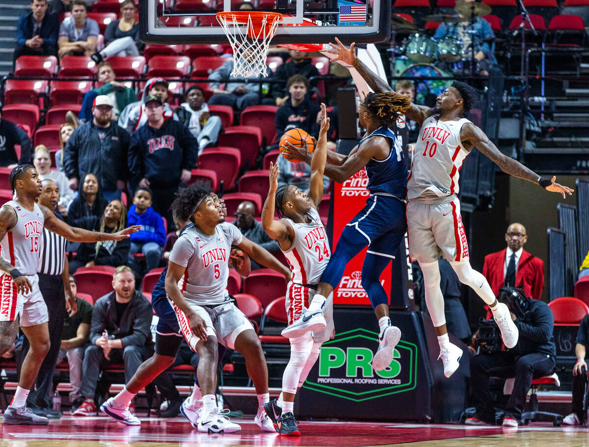 UNLV guard Jackie Johnson III (24) and forward Kalib Boone (10) double team Utah State Aggies g ...