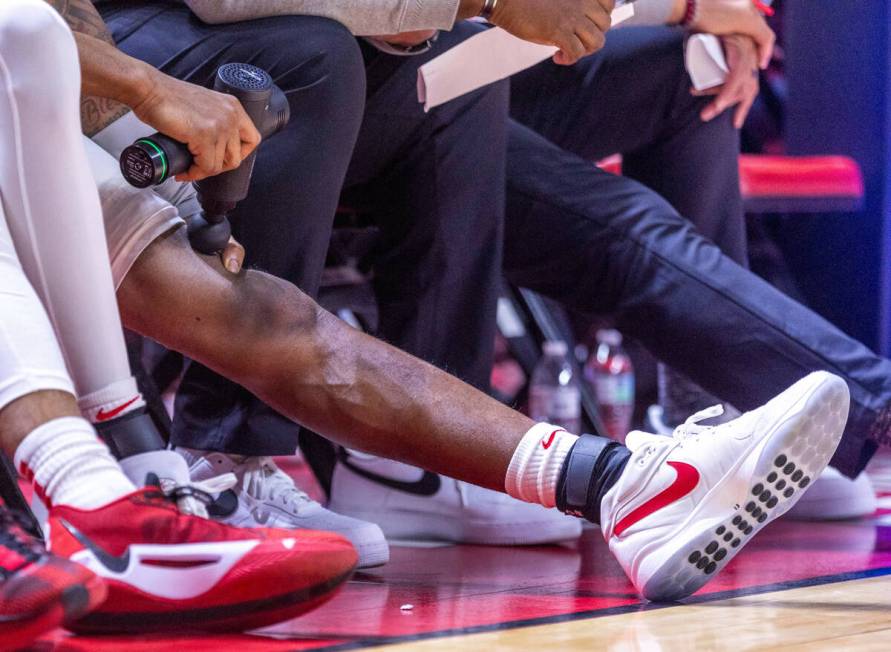 UNLV forward Keylan Boone (20) massages his left knee on the bench against the Utah State Aggie ...