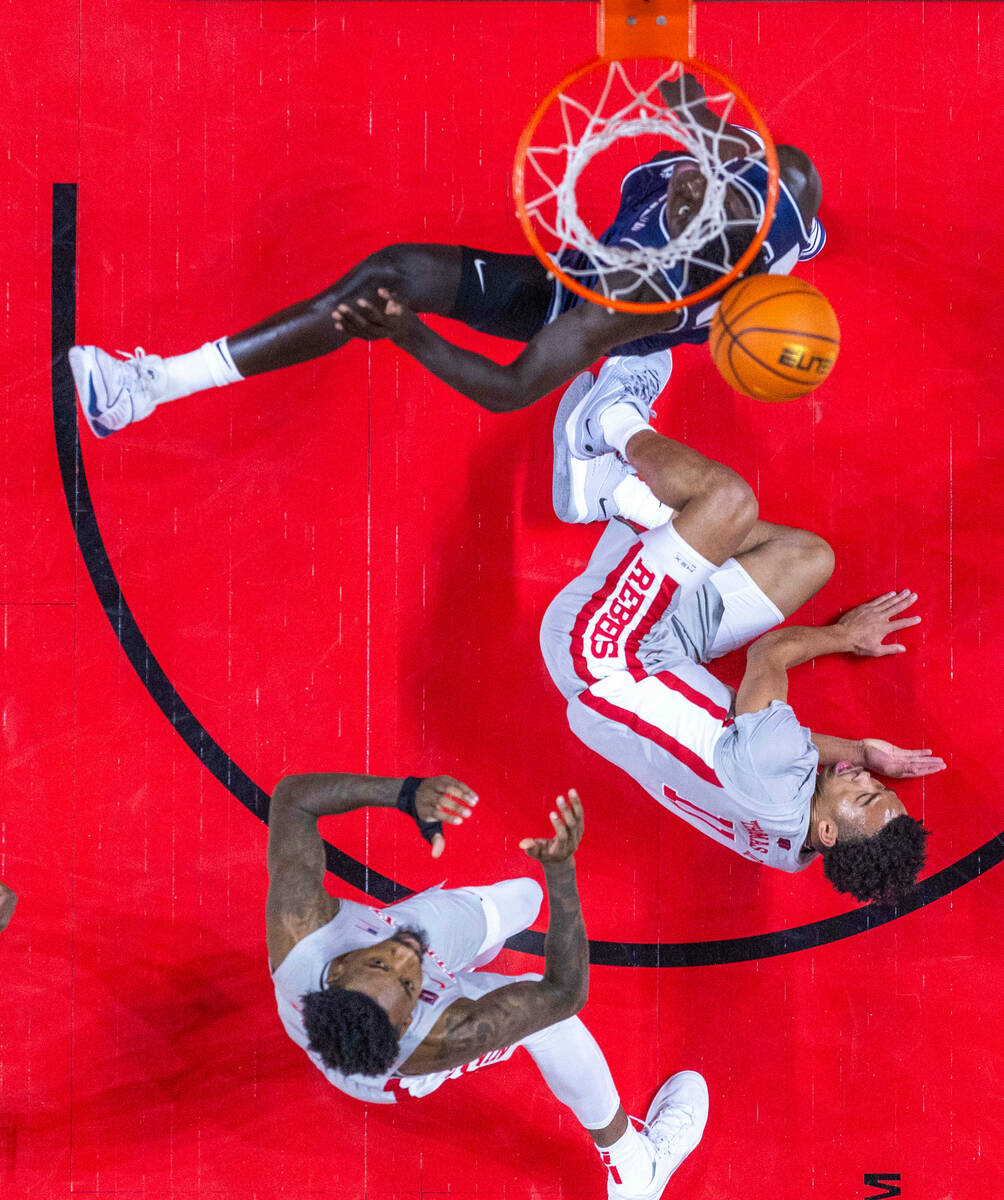 Utah State Aggies forward Great Osobor (1) looks to the ball as UNLV forward Kalib Boone (10) c ...