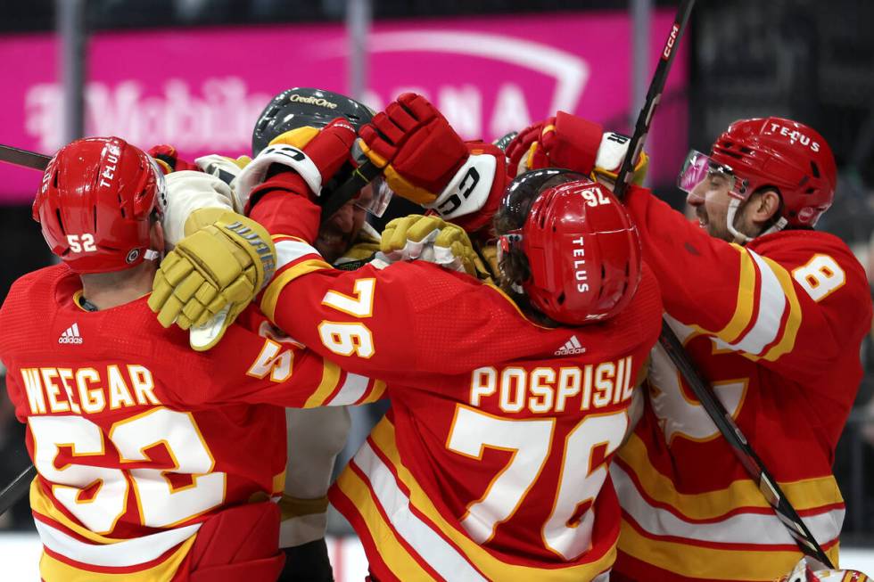 Golden Knights right wing Mark Stone (61) fights with Flames center Martin Pospisil (76) during ...